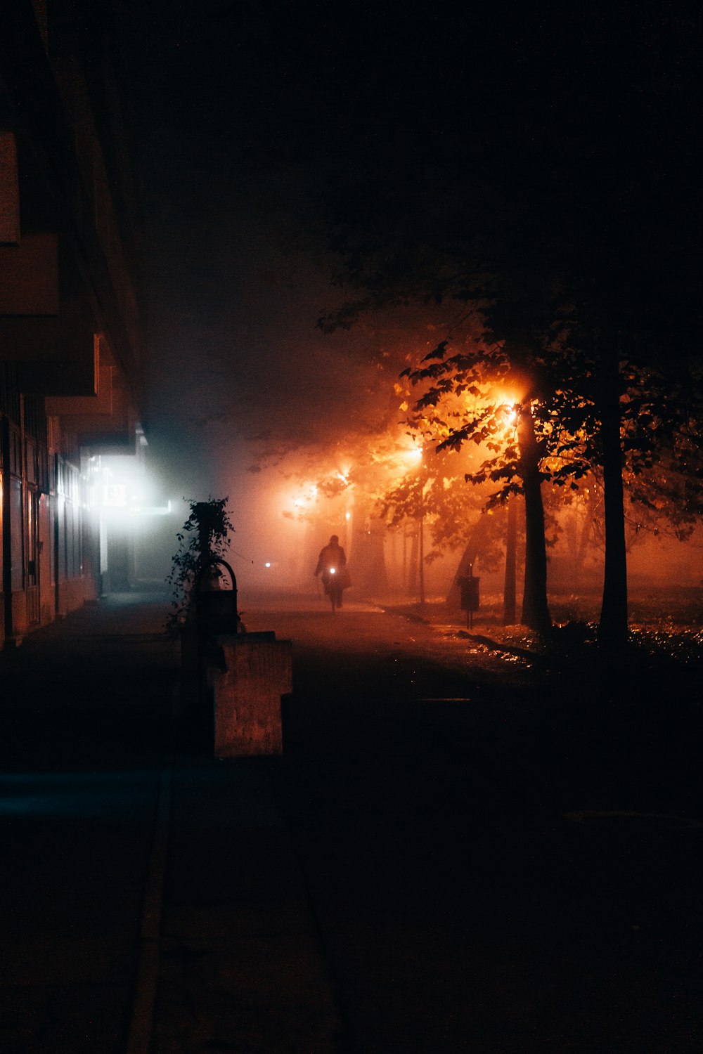 a person walking in front of a fire at night