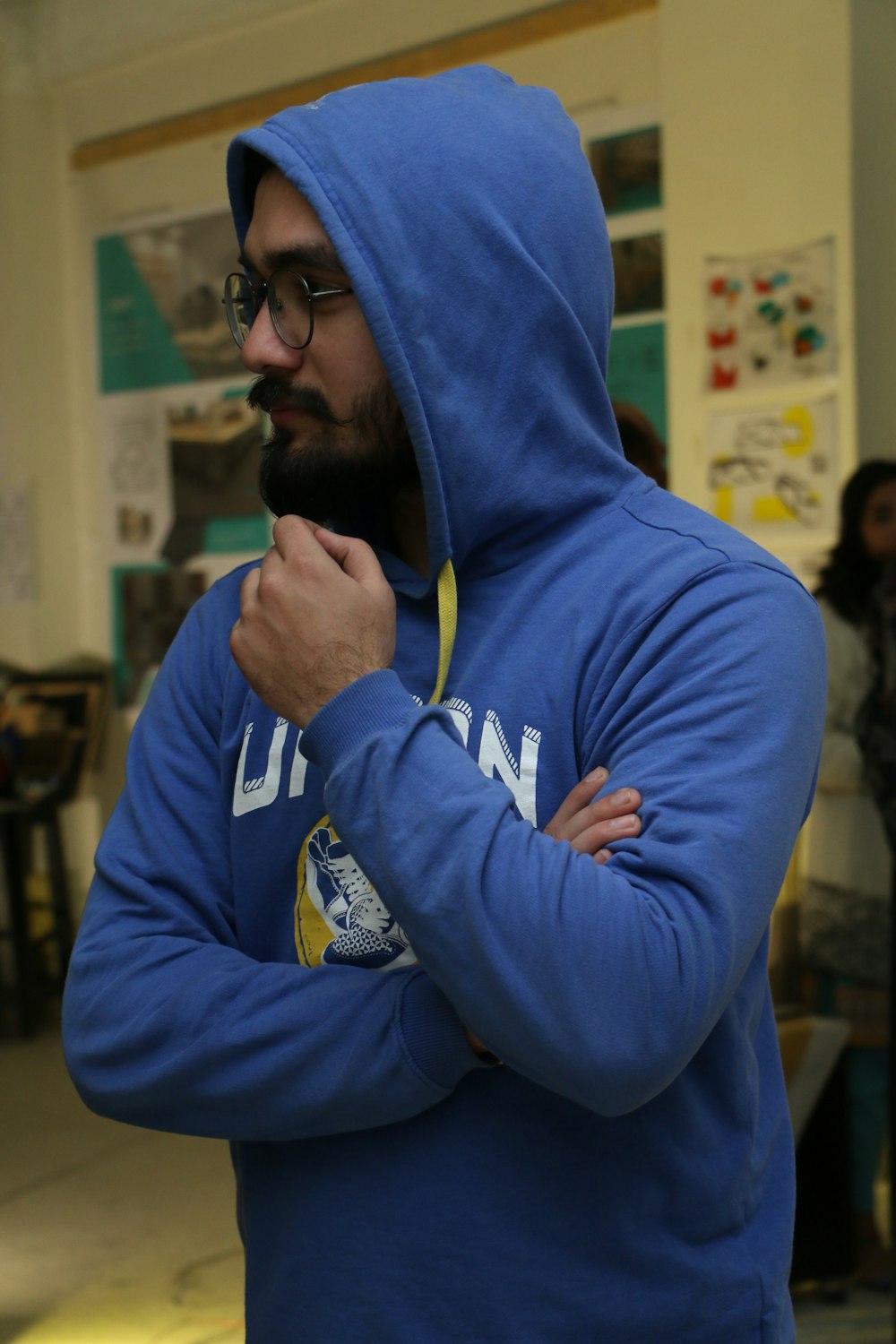 a man wearing a blue hoodie and holding a yellow stick