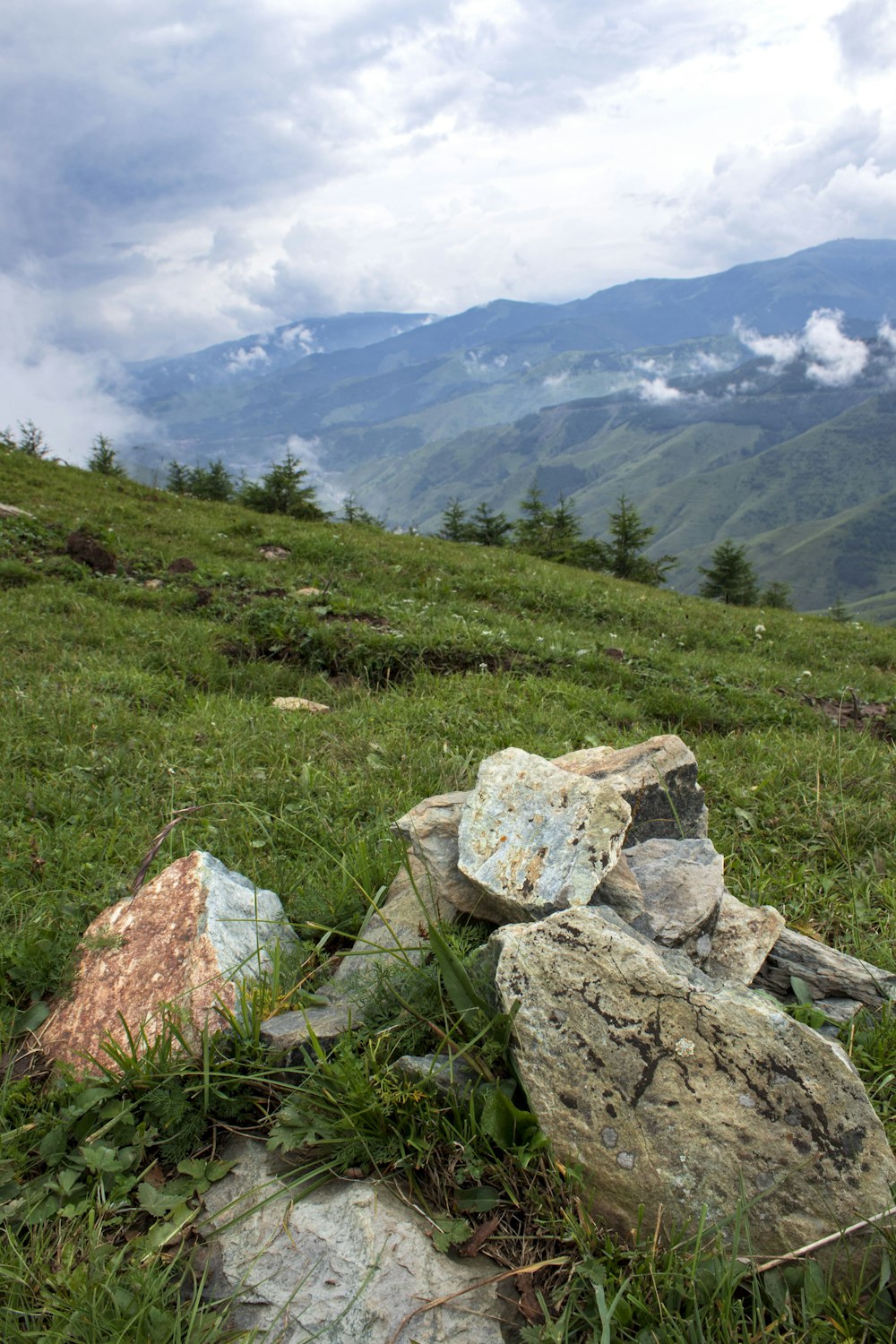 a grassy hill with rocks on it