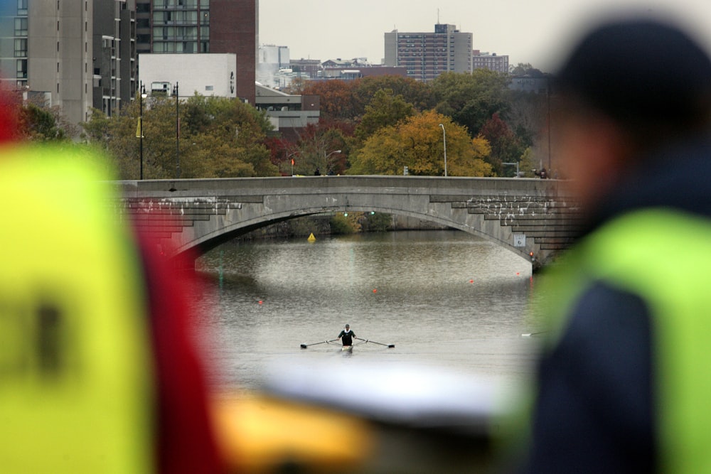 a person looking out a window at a bridge over a river