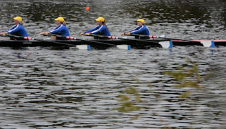Teams of rowers united in synchronized paddling, smiling and cheering on the water.