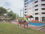 A modern playground surrounded by vibrant flower beds in a residential complex.