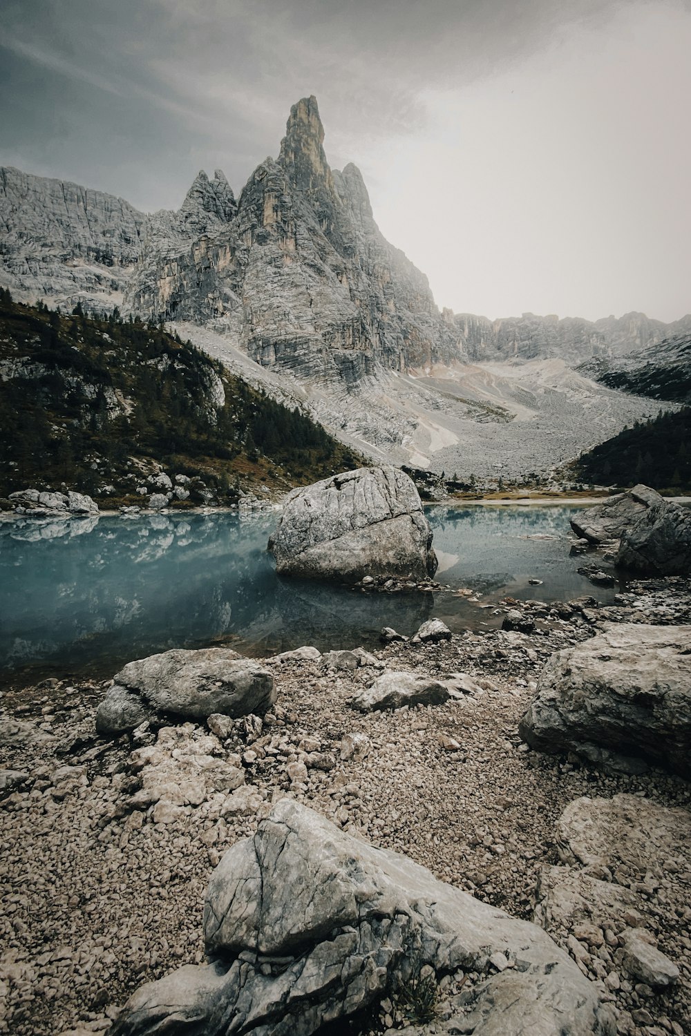 a rocky mountain with a body of water in front of it