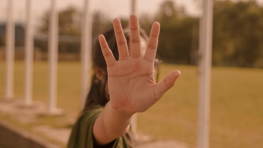 a woman's hand with a green shirt and a green sweater