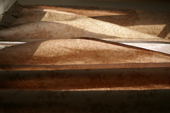 Elegant drapes with subtle Chinese-inspired patterns softly filtering warm afternoon light.