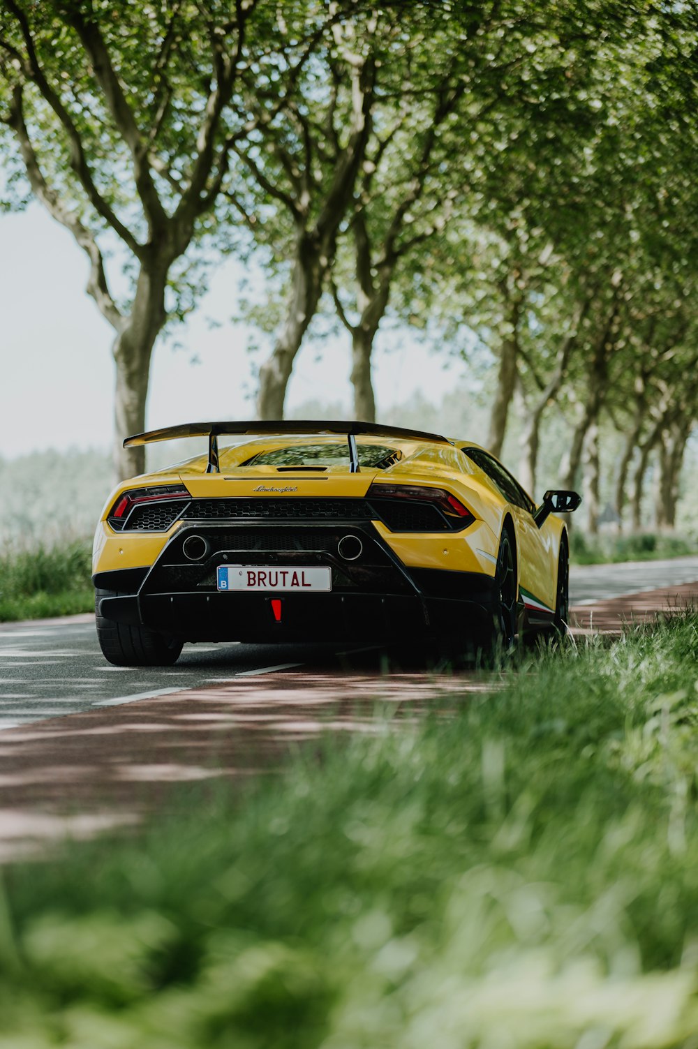 a yellow sports car on a road