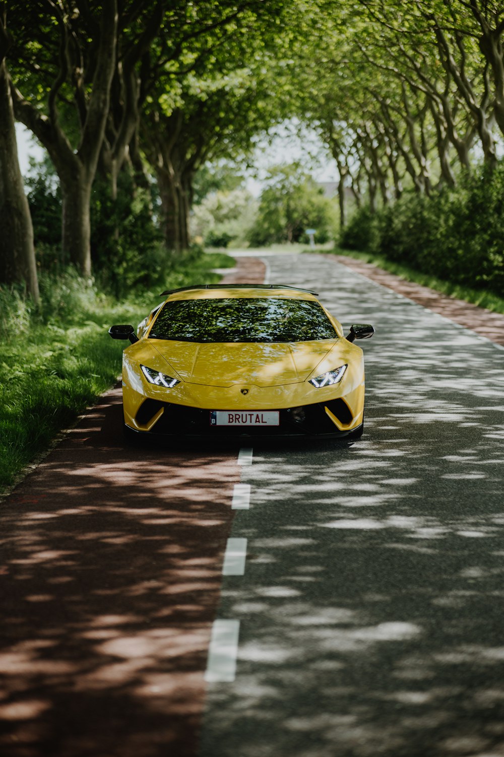 a yellow sports car on a road