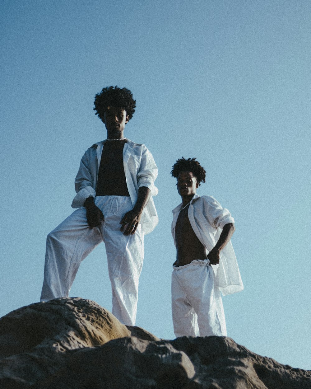 a man and a woman standing on a rock