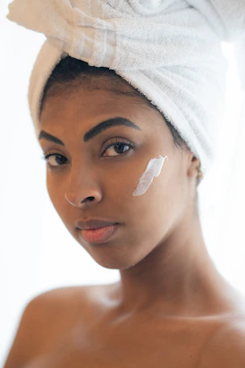 A serene face with glowing skin, resting gently on a soft white towel.