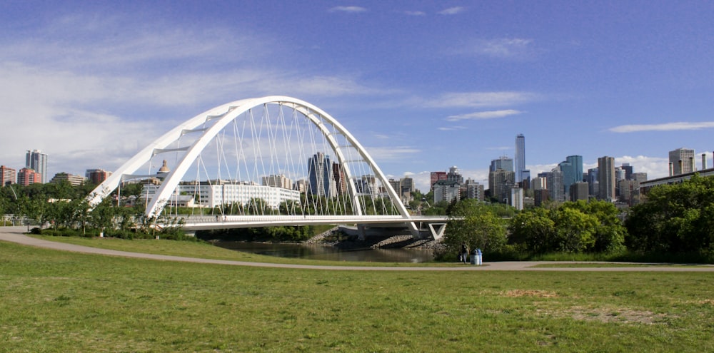 a large white building with a glass roof surrounded by trees and Juscelino Kubitschek bridge