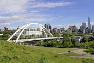 a bridge over a river with a city in the background