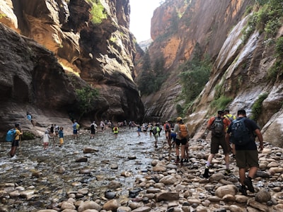 Travelers hiking through the dramatic canyons of Wadi Shab.