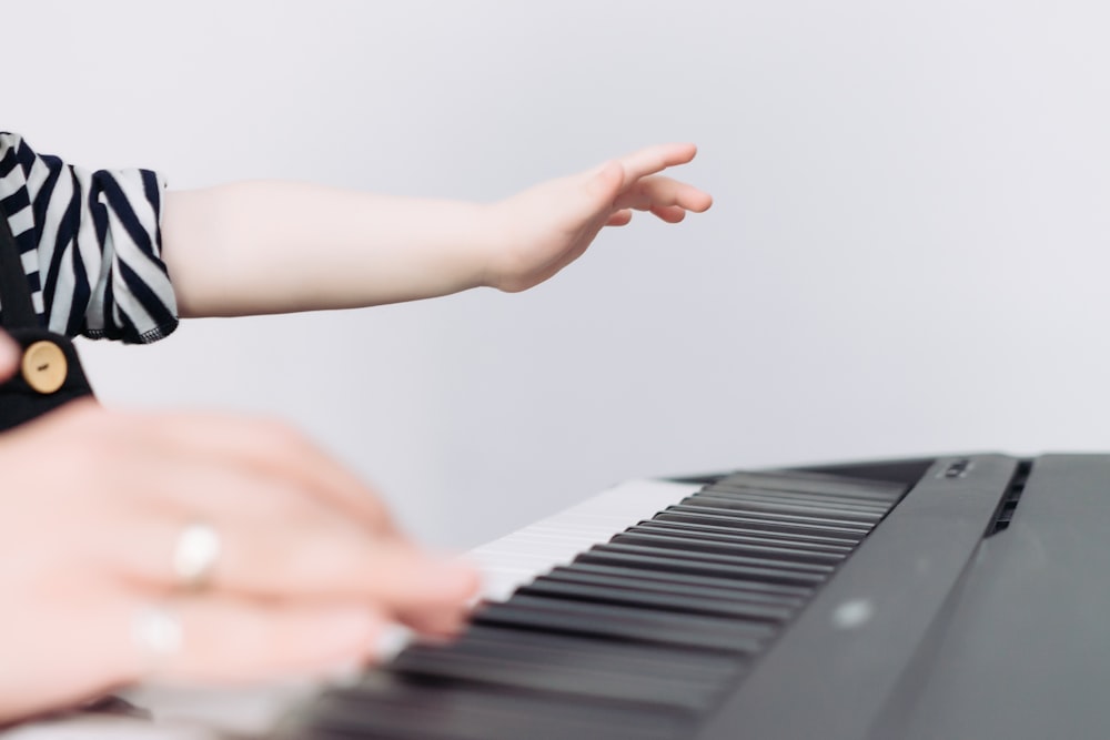 la main d’une personne touchant un clavier de piano