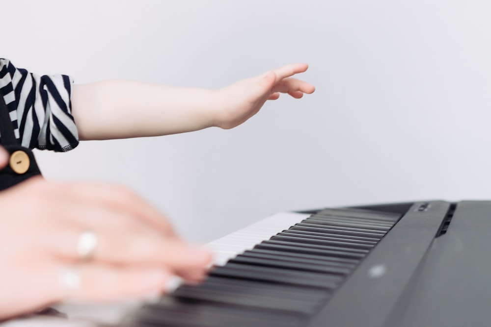 a person's hand touching a piano keyboard