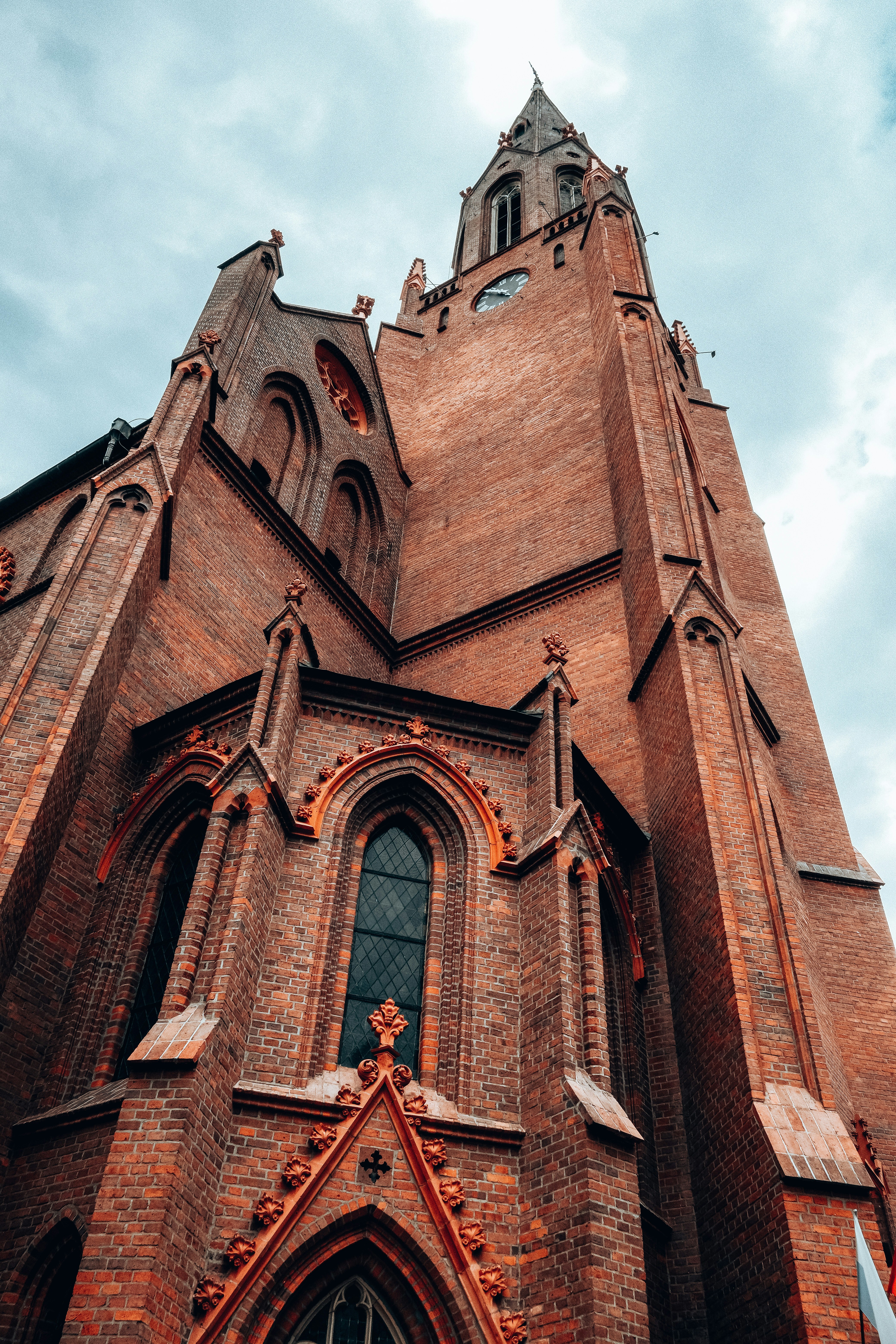 a large brick building with a clock with Golden Gate, Kiev in the background
