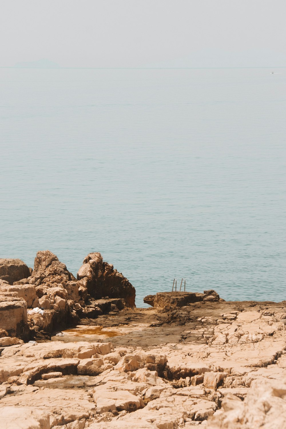 a rocky beach with a body of water in the background