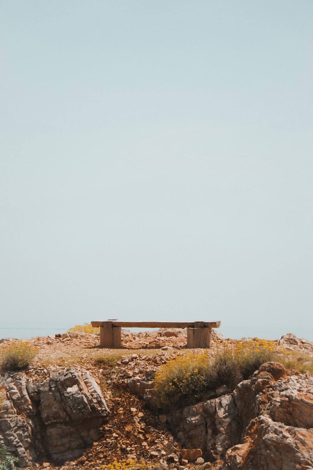 a bench sits in the middle of a rocky area