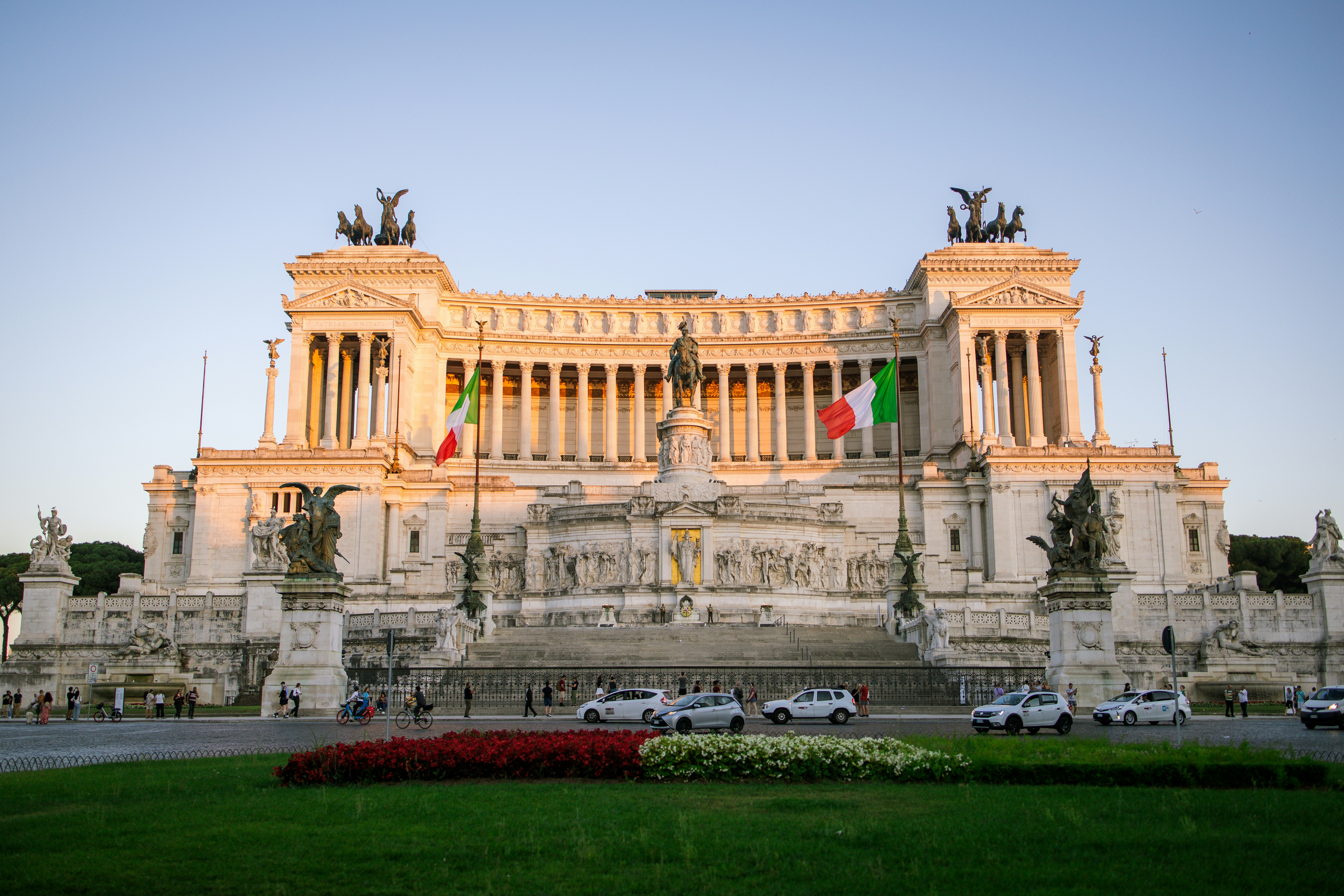 a large building with columns and statues with Altare della Patria in the background