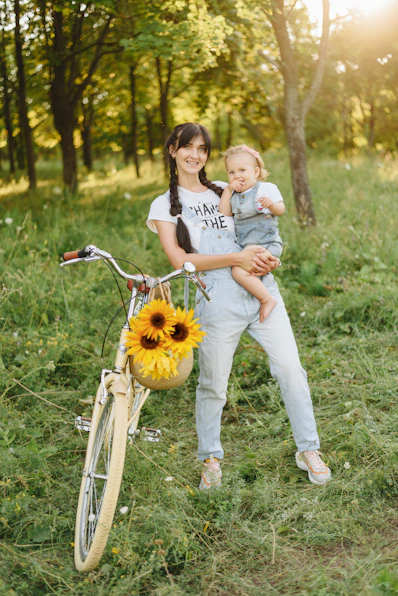 a person holding a child on a bike in a park