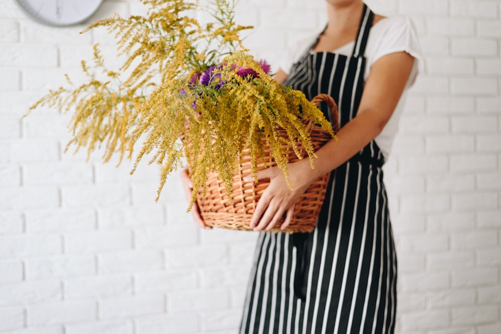 a person holding a basket of flowers