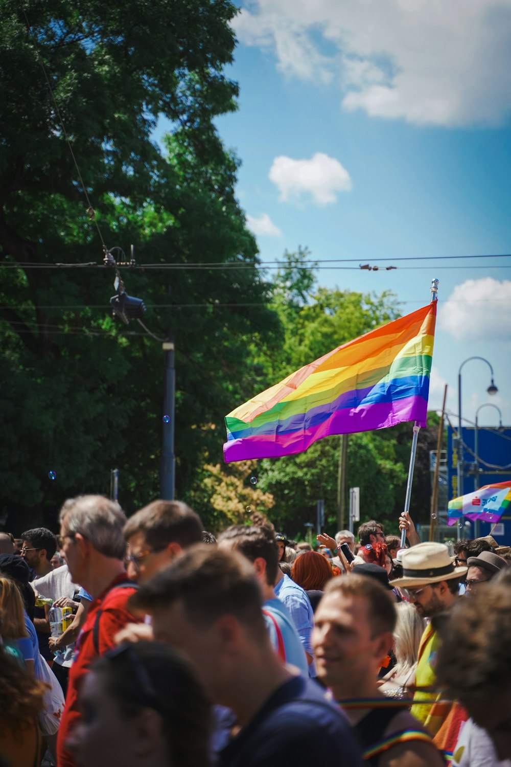 a crowd of people holding a rainbow flag
