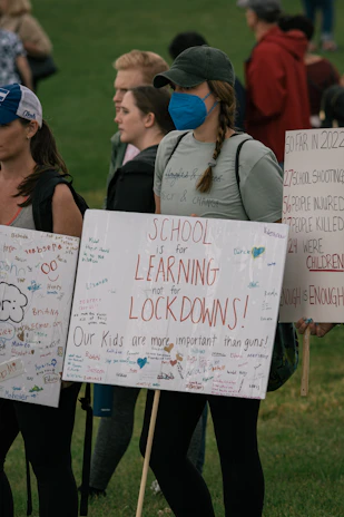 Children holding handmade signs of hope and gratitude at a community gathering.