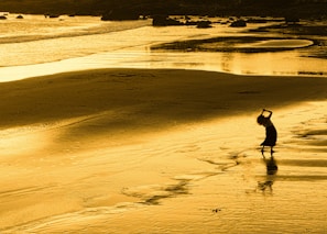 A vibrant travel influencer posing with a stunning beach backdrop at sunset.
