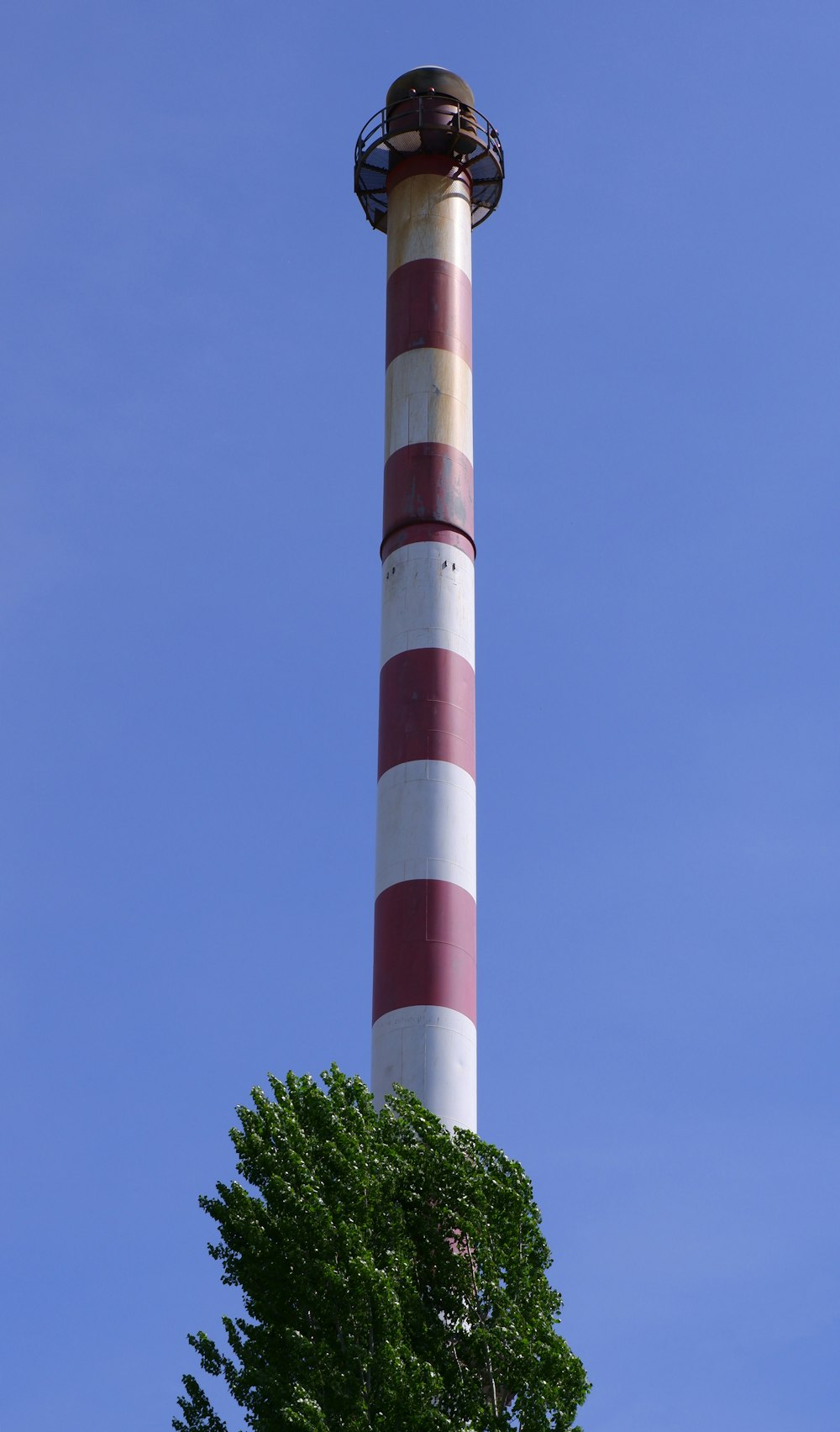 a tall tower with a tree in front of it