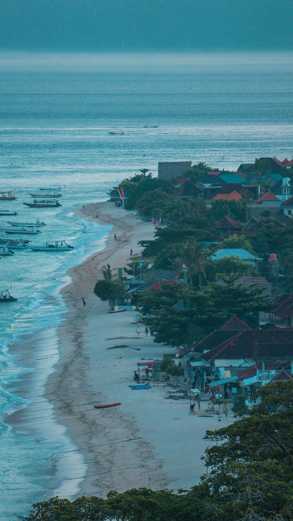 a beach with boats and houses