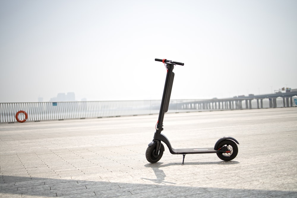a wheeled scooter on a concrete surface with a body of water in the background