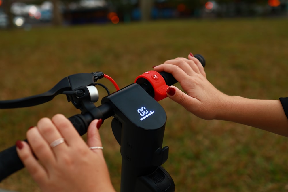 a person holding a black and red object with a handle