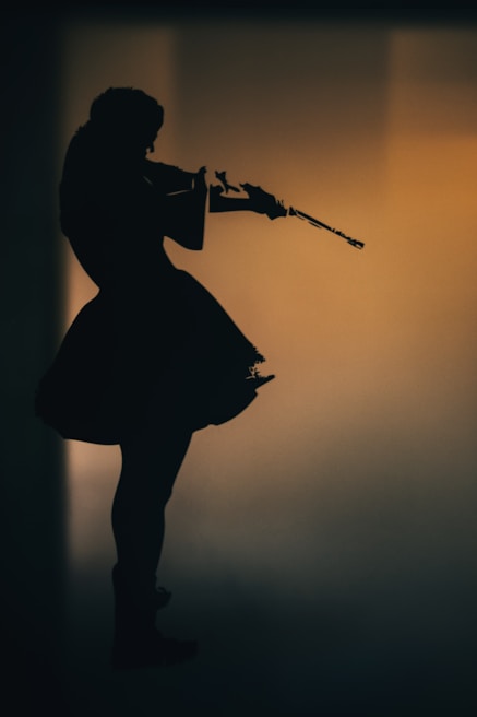 An artist passionately playing a violin in a dimly lit studio.