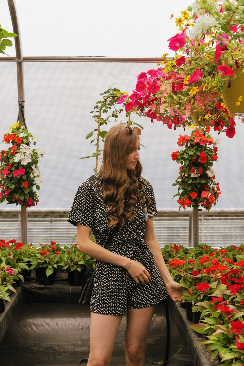 a woman standing in front of a flower arrangement