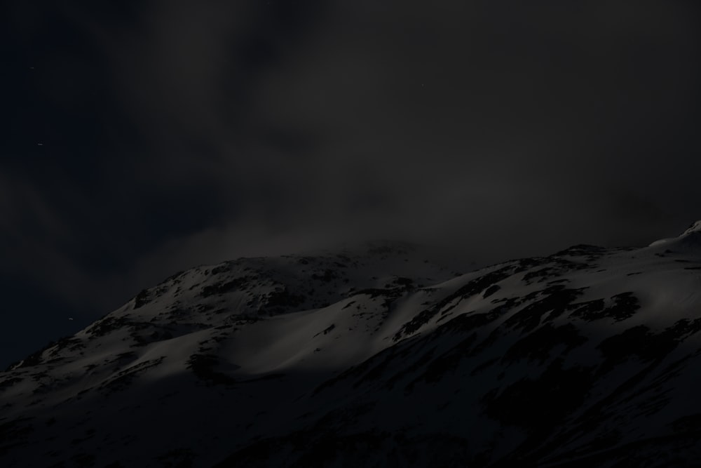 a snowy mountain with a dark sky