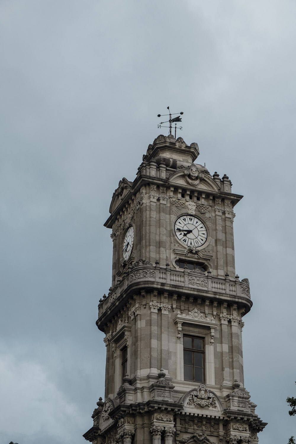 a clock tower with a weather vane