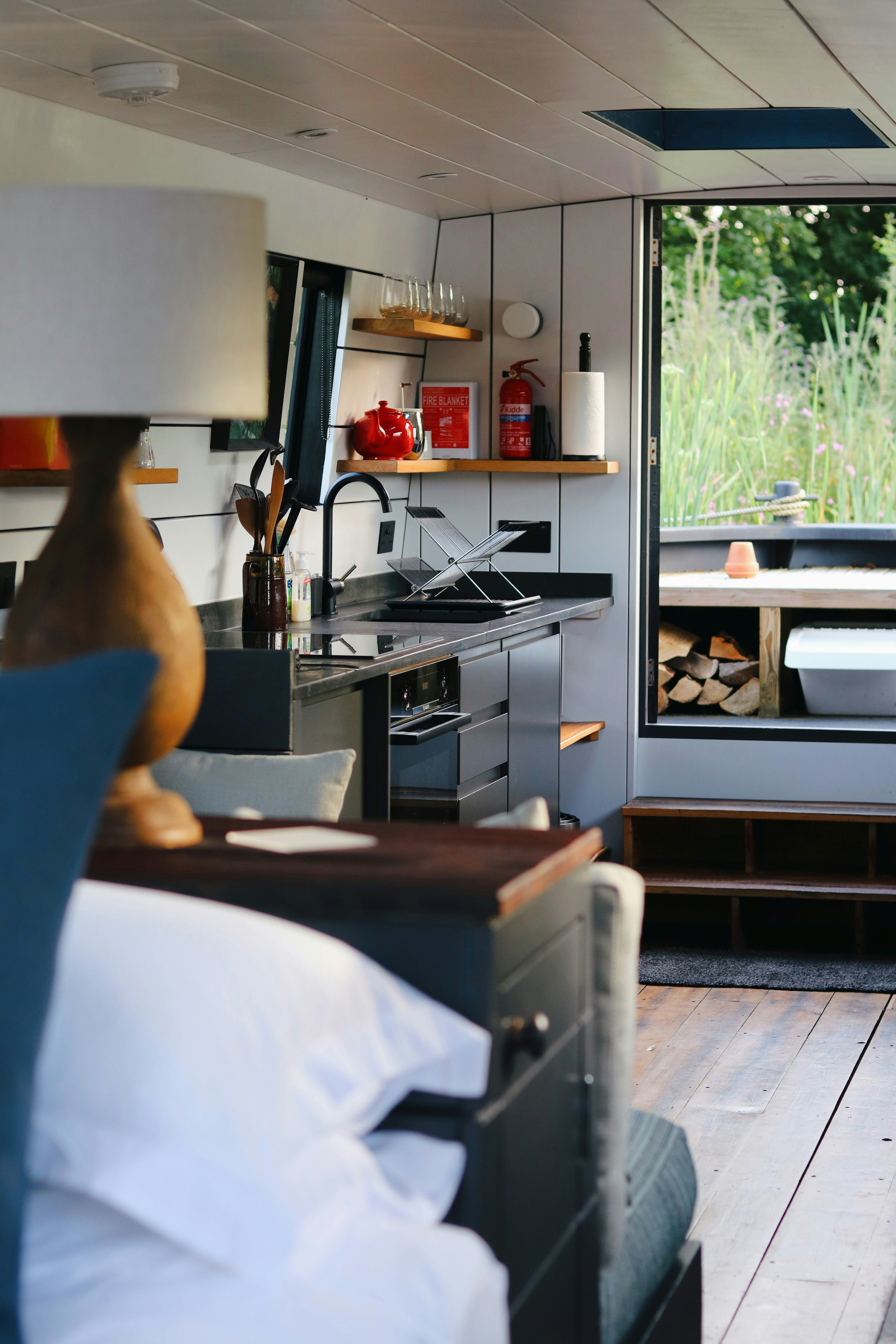 La mano de una persona sosteniendo un objeto blanco frente a una cocina