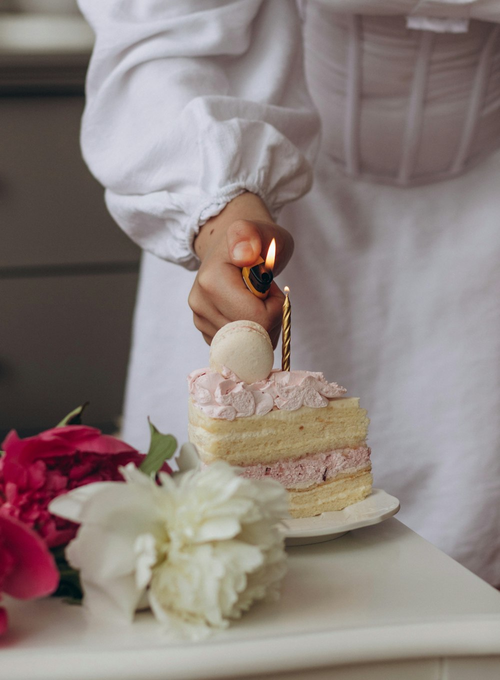 a person lighting a candle on a cake