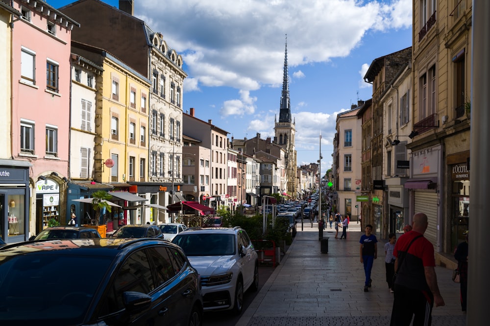 a street with cars and people on it and buildings on the side