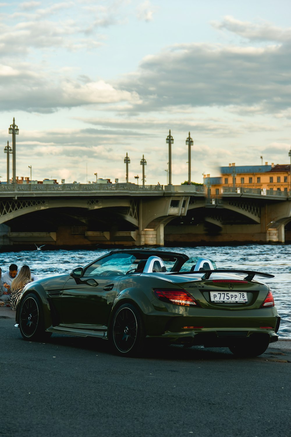 a black sports car parked on a road by a bridge