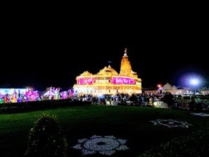 Crowds gathering at a temple festival with vibrant lights and music