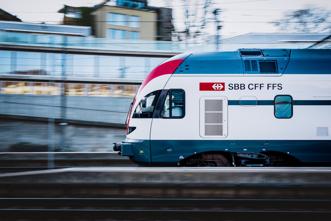 a train on the tracks, A Regional train leaving a station with an office building in the background
