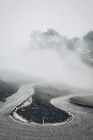 A winding mountain trail disappearing into a foggy horizon.