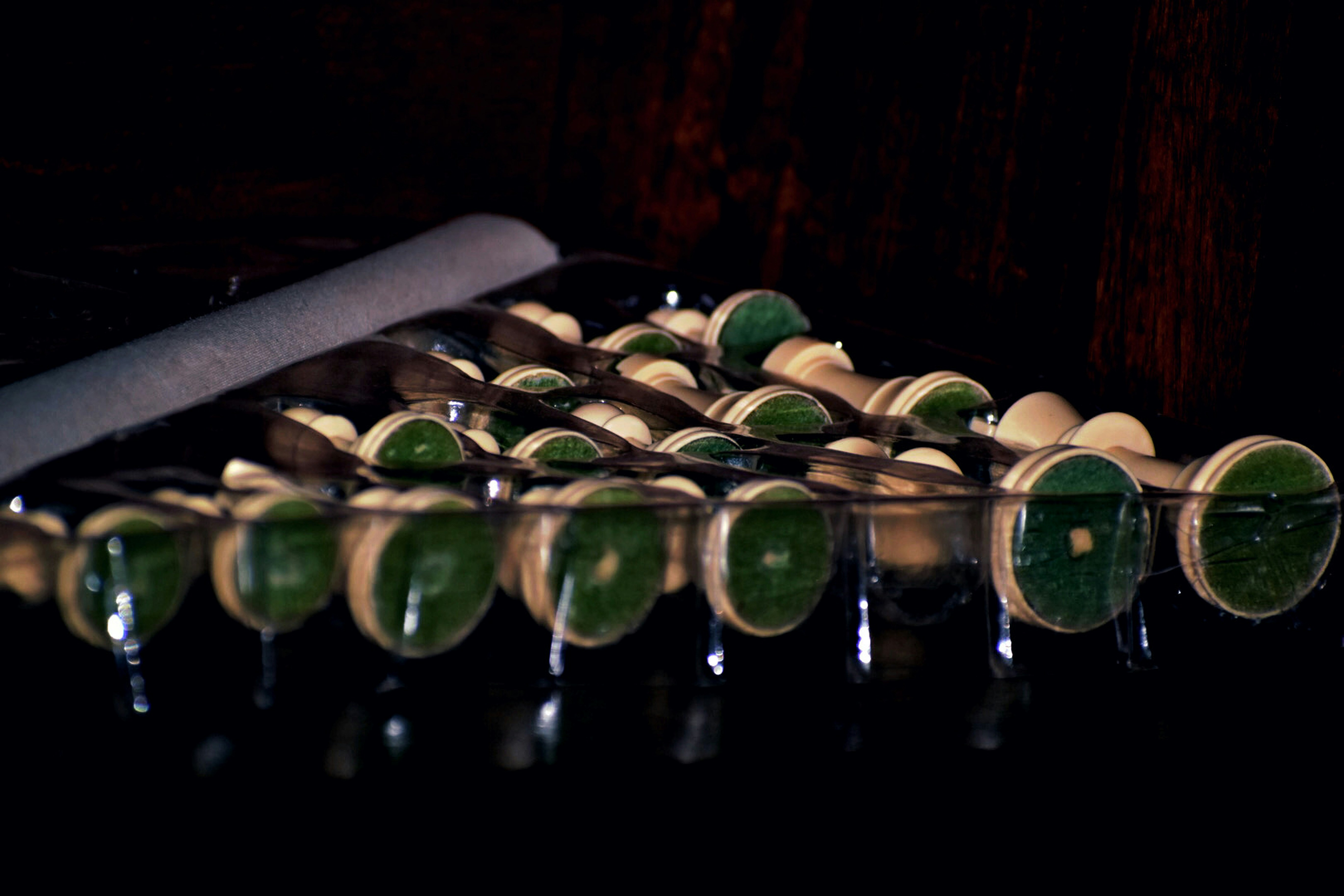 a knife cutting a glass of green liquid
