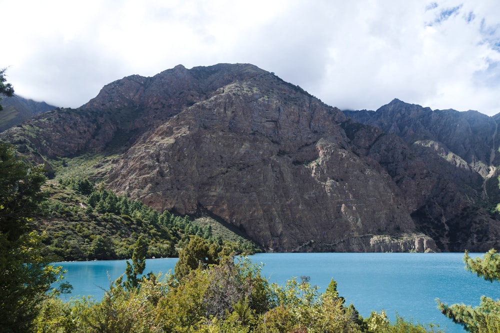 a body of water with a rocky mountain in the background