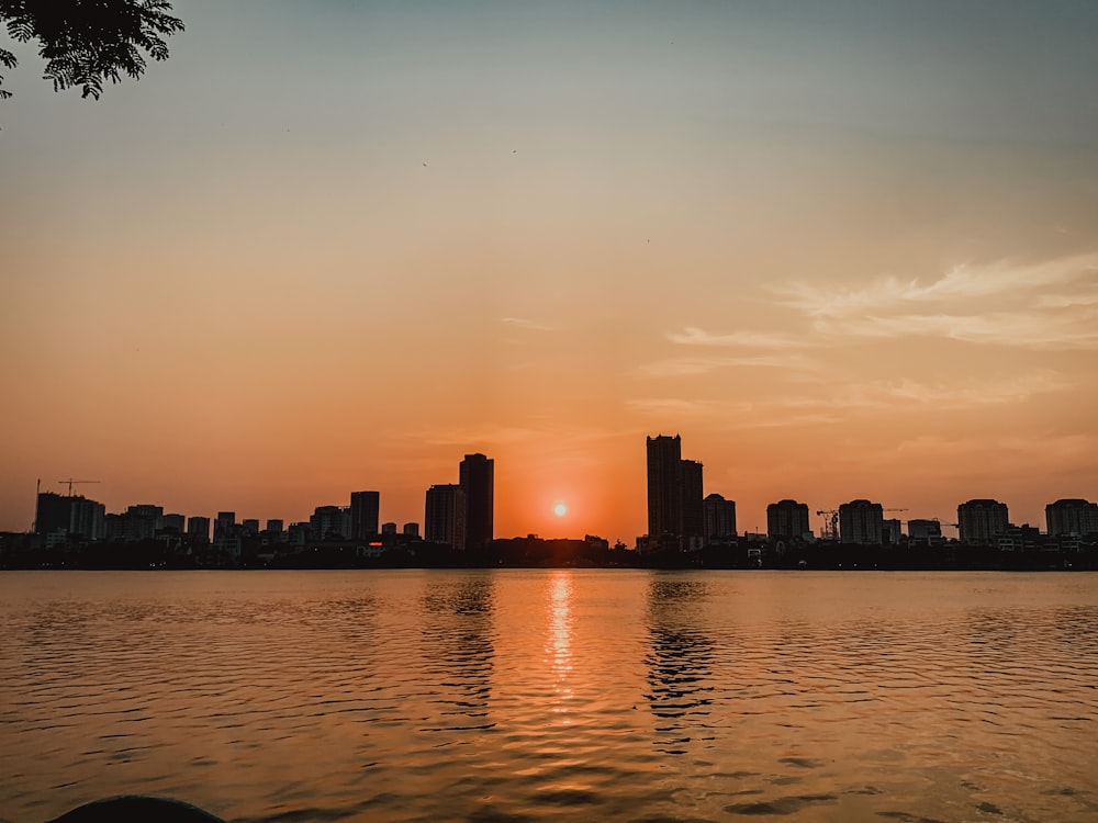 a city skyline with the sun setting