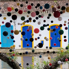 A playful scene with a cat wearing a handmade dress surrounded by colorful yarn balls.