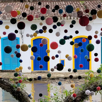 A playful scene with a cat wearing a handmade dress surrounded by colorful yarn balls.
