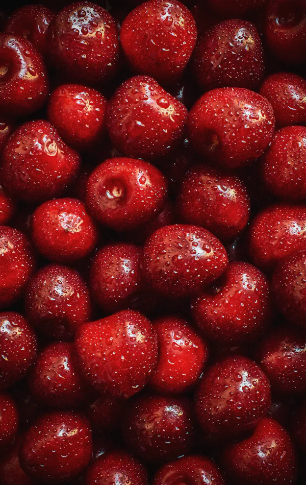 Fruits rouges gorgés de jus en gros plan — la fraise rouge fraîche en tête de Black Opium Pink Glaze d'Yves Saint Laurent chez Olara