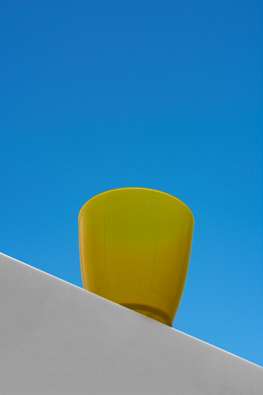 a yellow ball on a white surface
