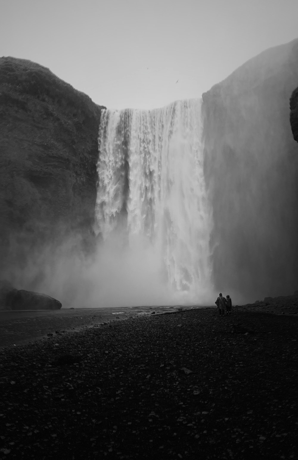 a group of people standing in front of a waterfall